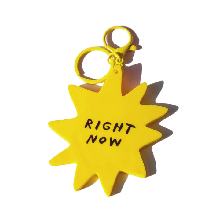 Yellow star-shaped keychain with 'RIGHT NOW' text on a white background