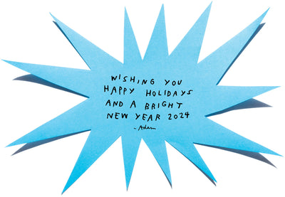 a photo of a blue paper starburst shape has a handwritten note that reads: wishing you happy holidays and a bright new year 2024 - adam