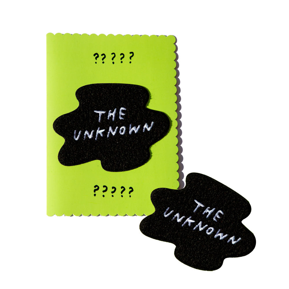 Green greeting card with embroidery patch. Patch reads "THE UNKNOWN" in blob shape.