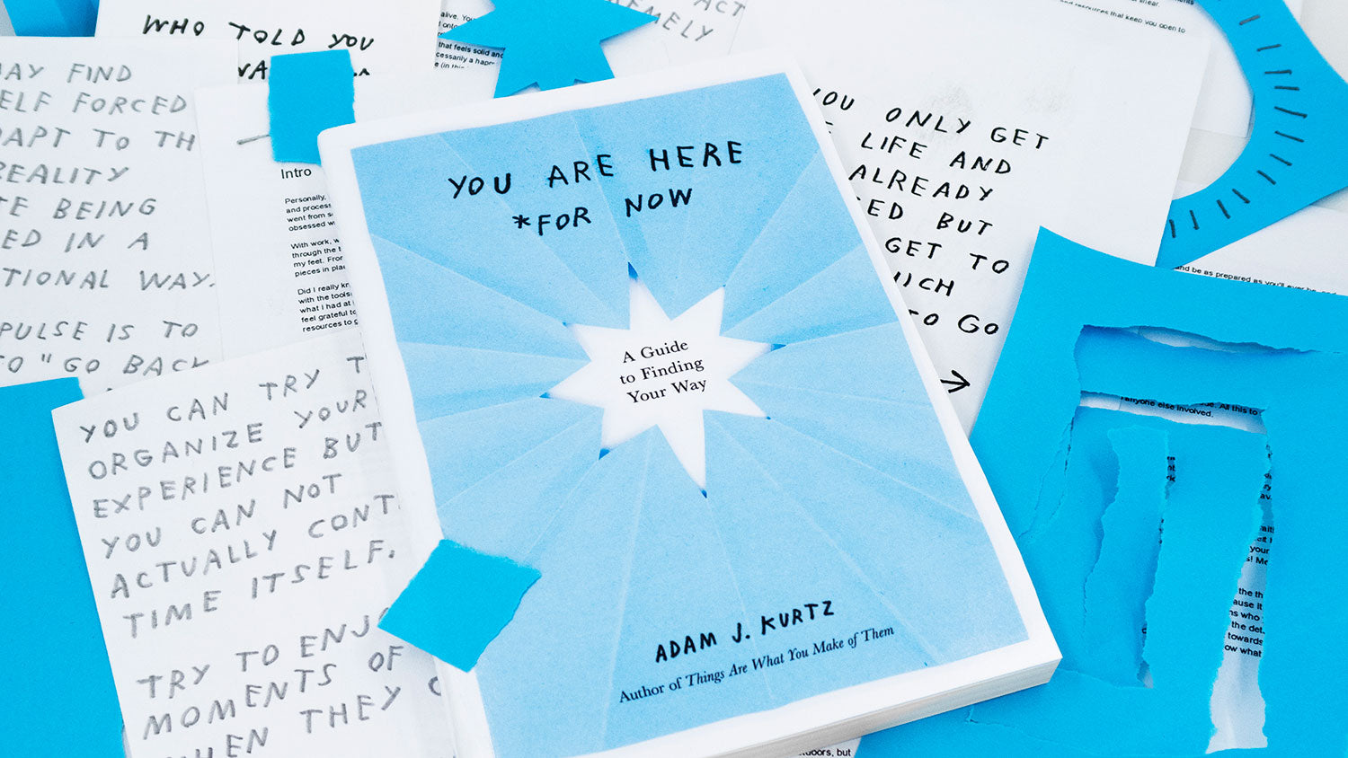 Photo of book surrounded by paper scraps and sketches. You Are Here *For Now book by Adam J. Kurtz Adam JK @adamjk YAHFN @yahfn